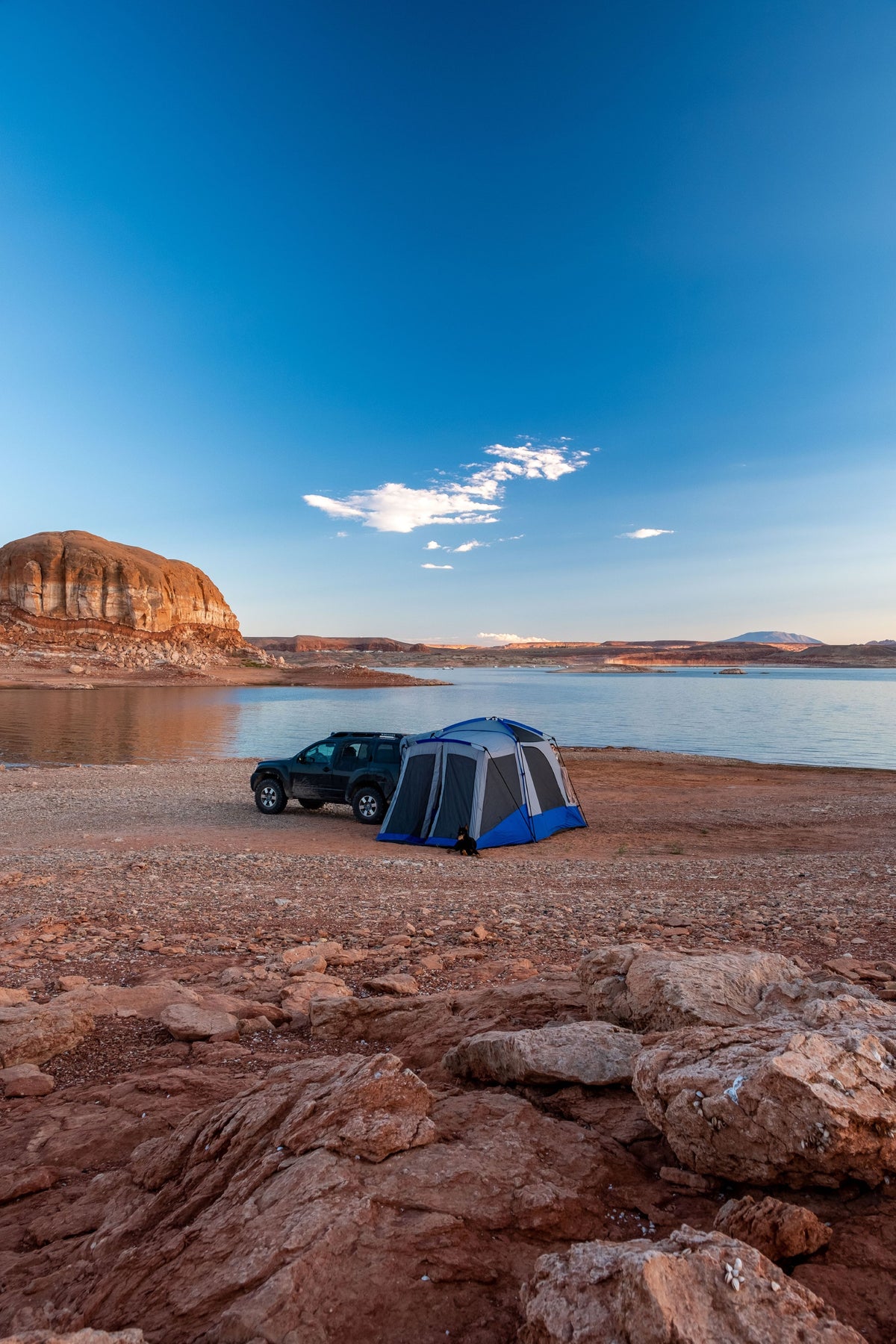 SUV tent set up next to the lake for overlanding camping