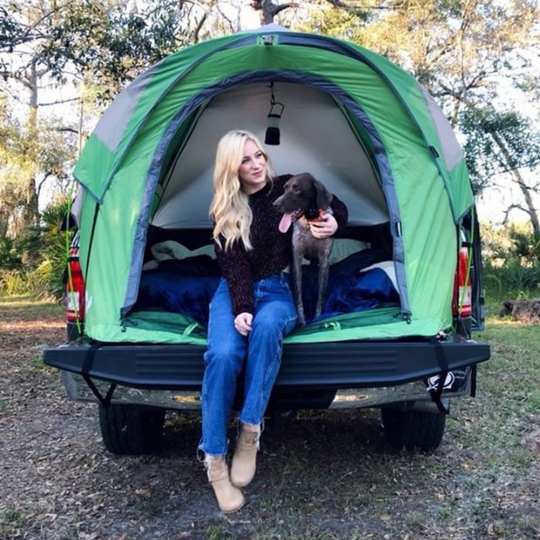 Girl and dog inside a napier backroadz truck tent green and grey